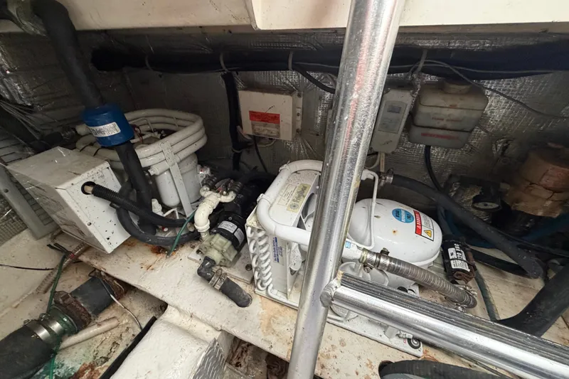 Slide: The Image of Engine room of 1997 Fifth Ocean Yachts 40, showcasing mechanical components and piping. - 16