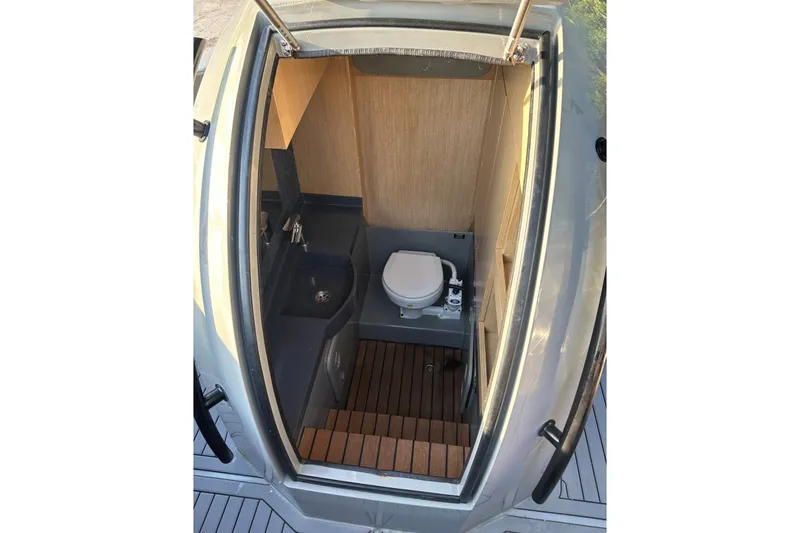 Slide: The Image of 2020 Dromeas D28 CC boat interior with compact bathroom, featuring a toilet and sink. - 8