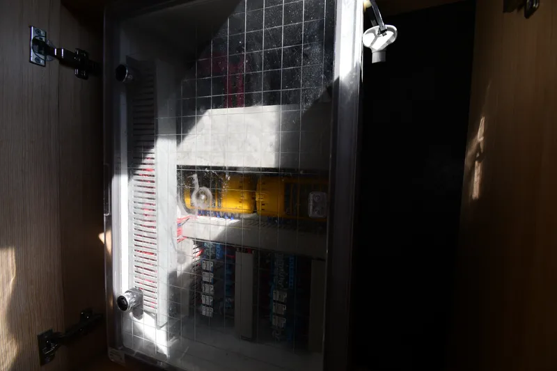 Slide: The Image of Electrical panel inside a 2020 Dromeas D28 CC boat, partially illuminated by sunlight. - 27