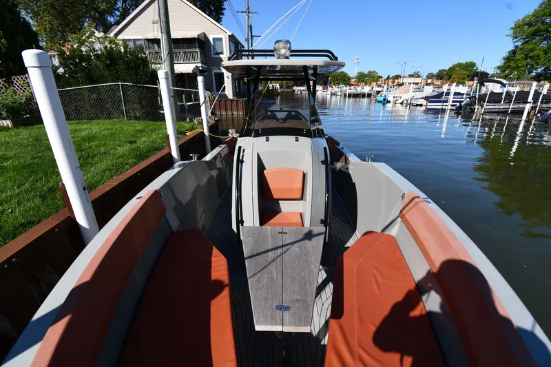 Slide: The Image of 2020 Dromeas D28 CC boat docked, featuring orange seating and sleek design. - 5