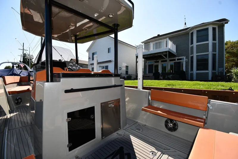 Slide: The Image of 2020 Dromeas D28 CC boat interior with seating, docked near modern houses. - 13