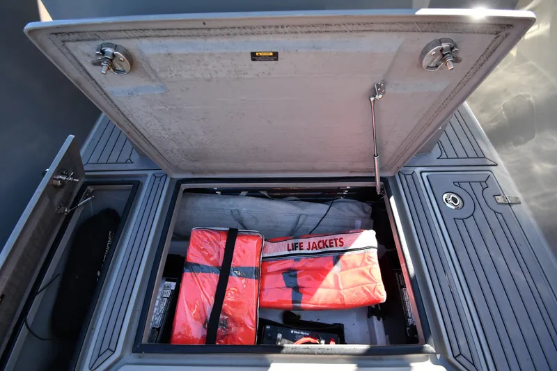 Slide: The Image of Open storage compartment on 2020 Dromeas D28 CC boat with life jackets inside. - 29