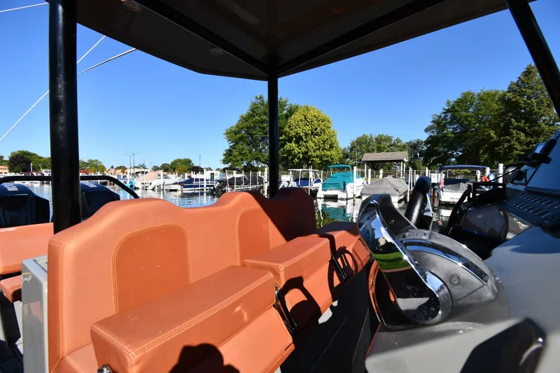 Slide: The Image of Interior view of 2020 Dromeas D28 CC boat with brown seating at a marina. - 12