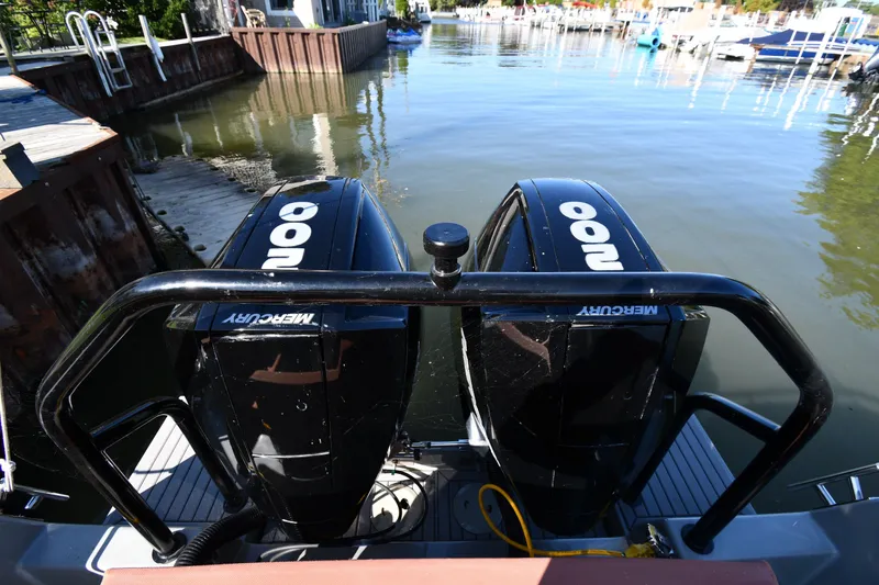 Slide: The Image of Twin Mercury outboard engines on a 2020 Dromeas D28 CC boat docked in a marina. - 6