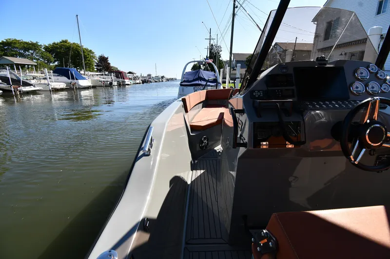 Slide: The Image of 2020 Dromeas D28 CC boat interior with modern dashboard, docked in a marina. - 18