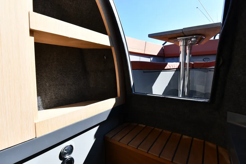 Slide: The Image of Interior view of 2020 Dromeas D28 CC boat, featuring wooden shelves and seating. - 26