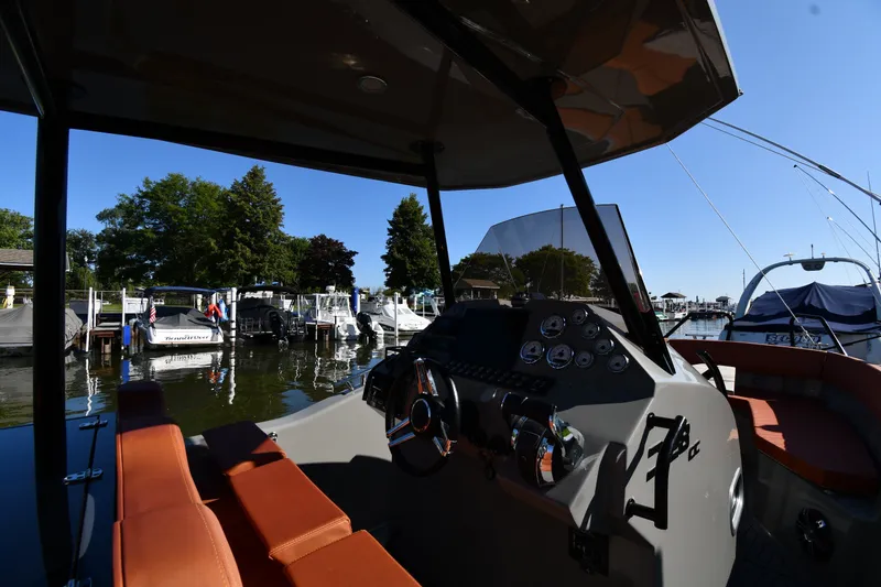 Slide: The Image of 2020 Dromeas D28 CC boat interior at marina, featuring dashboard and seating. - 8