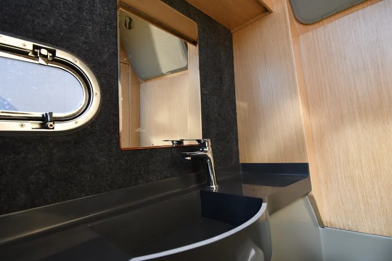 Slide: The Image of Interior of 2020 Dromeas D28 CC boat featuring a sleek sink and mirror setup. - 25