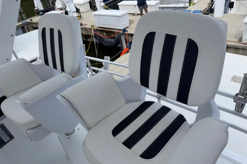 Slide: The Image of Captain's chairs on a 1999 Phoenix 38 SFX Convertible yacht, featuring striped upholstery. - 53