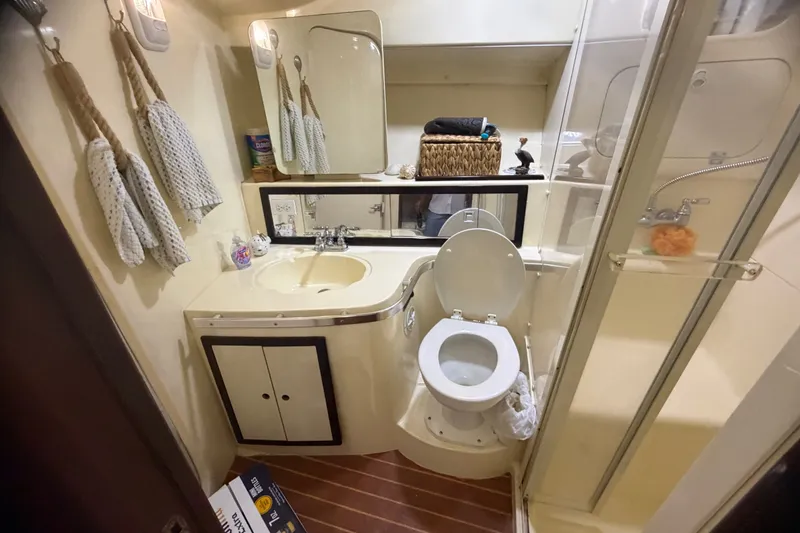 Slide: The Image of 1999 Phoenix 38 SFX Convertible yacht bathroom with sink, toilet, and shower. - 51