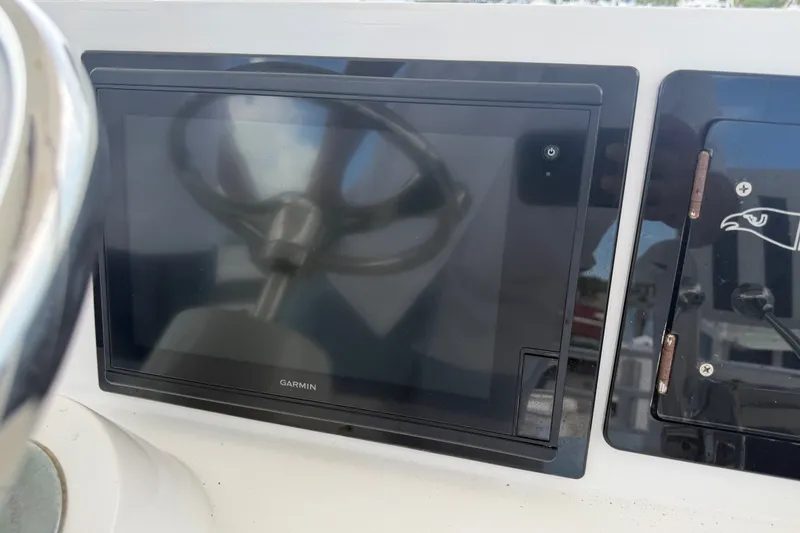 Slide: The Image of Control panel of a 1999 Phoenix 38 SFX Convertible with Garmin display and steering wheel. - 58