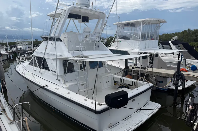Slide: The Image of 1999 Phoenix 38 SFX Convertible yacht docked at marina under cloudy sky. - 3