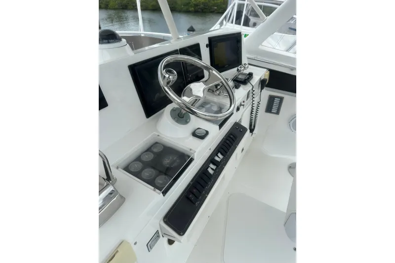 Slide: The Image of 1999 Phoenix 38 SFX Convertible boat helm with steering wheel and navigation controls. - 71