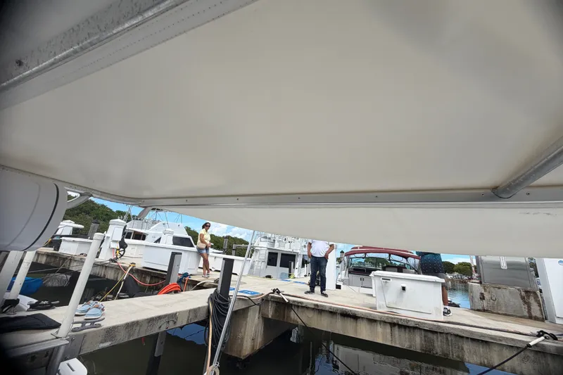 Slide: The Image of Docked Phoenix 38 SFX Convertible yacht, 1999 model, with people on the pier. - 24