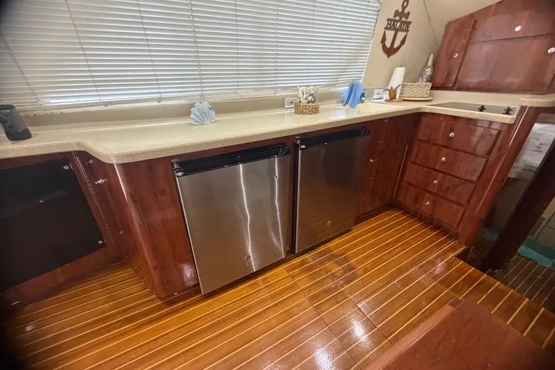 Slide: The Image of Luxurious kitchen interior of 1999 Phoenix 38 SFX Convertible yacht with wooden cabinetry and stainless appliances. - 28