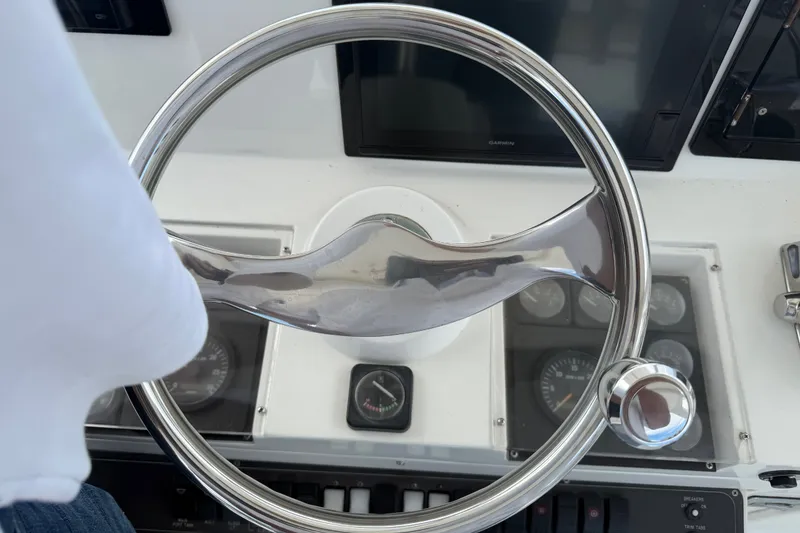 Slide: The Image of Steering wheel of a 1999 Phoenix 38 SFX Convertible boat with dashboard instruments. - 61