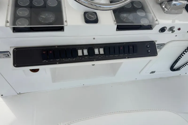 Slide: The Image of Control panel of a 1999 Phoenix 38 SFX Convertible boat with switches and gauges. - 64