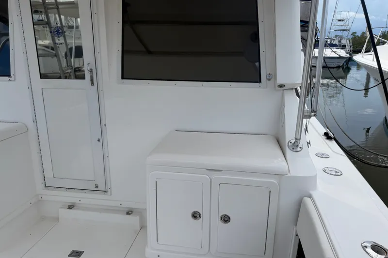 Slide: The Image of 1999 Phoenix 38 SFX Convertible boat interior with white seating and storage compartments. - 18