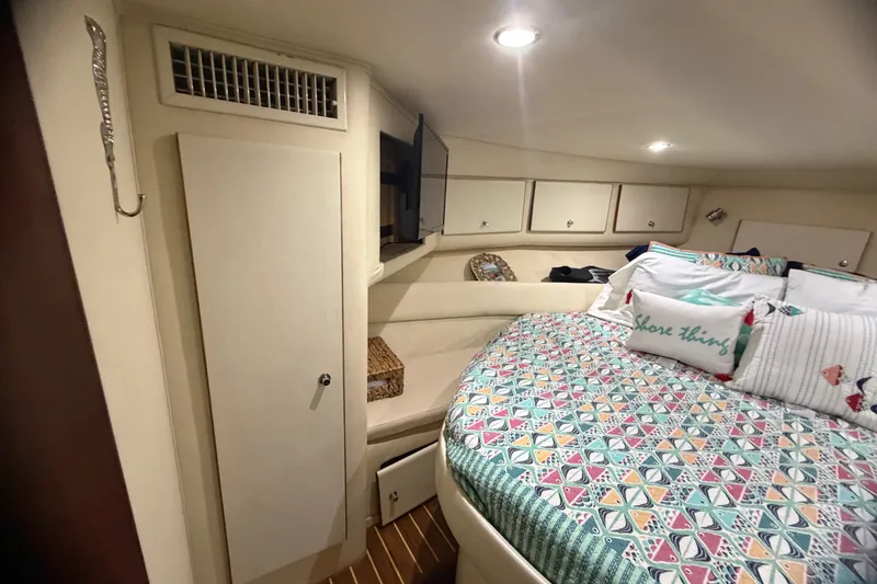 Slide: The Image of Cozy cabin interior of 1999 Phoenix 38 SFX Convertible with patterned bedding and storage. - 45