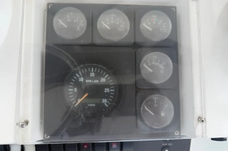 Slide: The Image of Dashboard gauges of a 1999 Phoenix 38 SFX Convertible boat, displaying RPM and fuel levels. - 62