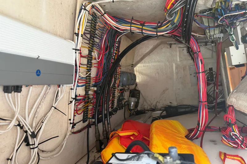 Slide: The Image of Electrical wiring inside a 1999 Phoenix 38 SFX Convertible boat, showcasing organized cables and components. - 65