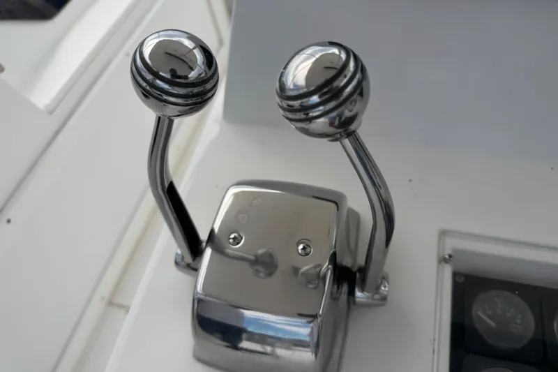 Slide: The Image of Chrome throttle controls on a 1999 Phoenix 38 SFX Convertible boat dashboard. - 60