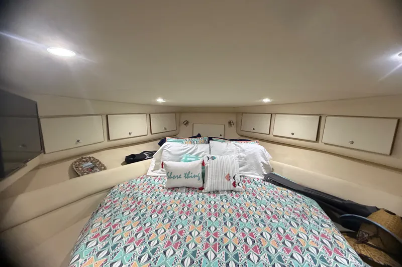 Slide: The Image of Cozy cabin interior of 1999 Phoenix 38 SFX Convertible with colorful bedding and ample storage. - 46