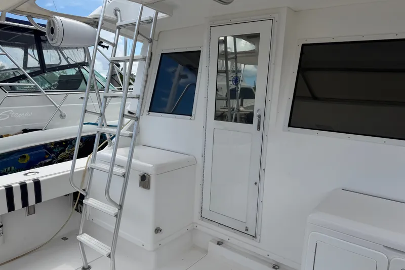 Slide: The Image of 1999 Phoenix 38 SFX Convertible boat interior with ladder and door, showcasing sleek design. - 19