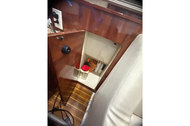 Slide: The Image of Open cabinet in 1999 Phoenix 38 SFX Convertible boat interior, showing storage space. - 35
