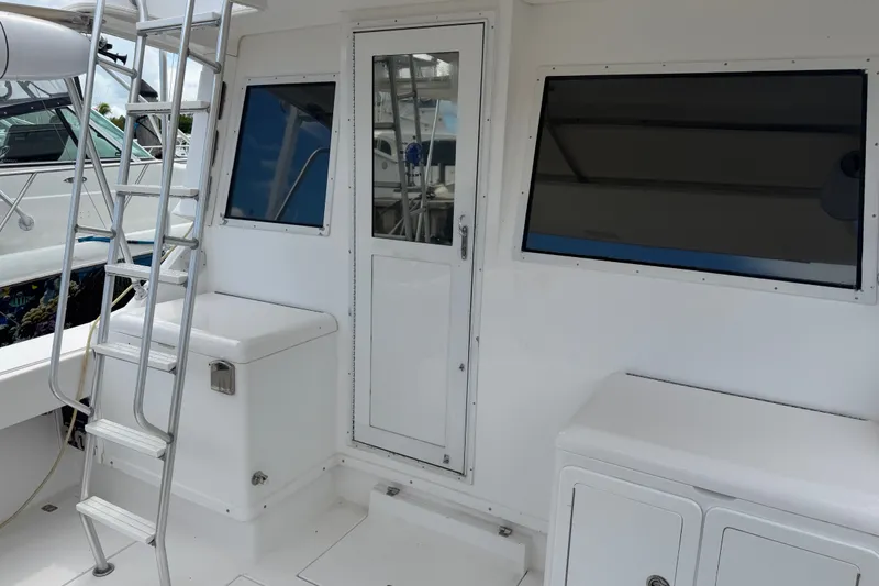 Slide: The Image of 1999 Phoenix 38 SFX Convertible boat deck with ladder and storage compartments. - 17