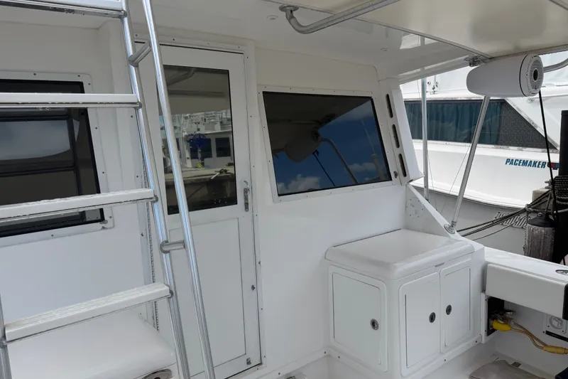 Slide: The Image of 1999 Phoenix 38 SFX Convertible yacht interior with ladder and storage compartments. - 21