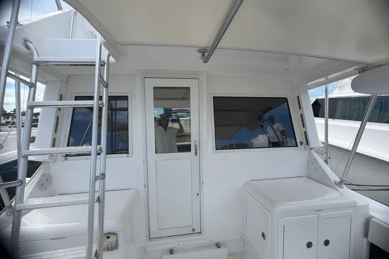 Slide: The Image of 1999 Phoenix 38 SFX Convertible yacht with ladder and cabin entrance. - 26