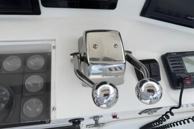 Slide: The Image of Control panel of a 1999 Phoenix 38 SFX Convertible boat with throttle levers and gauges. - 59
