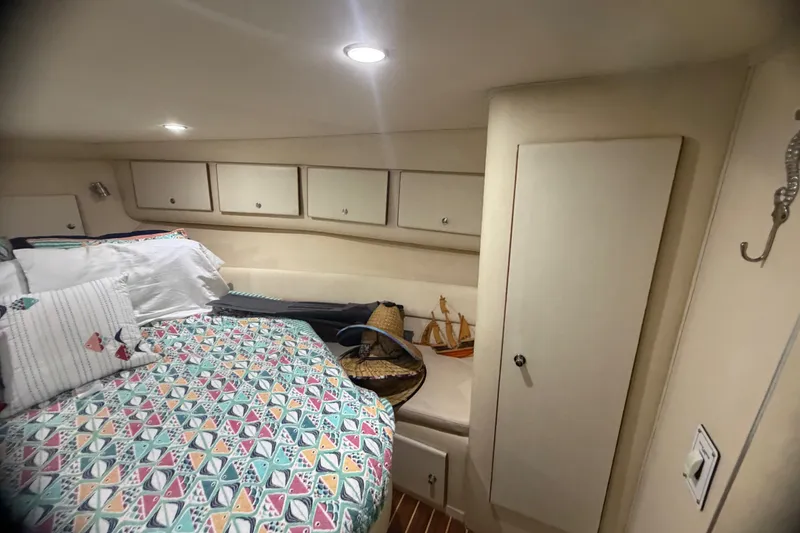 Slide: The Image of Cozy cabin interior of 1999 Phoenix 38 SFX Convertible with colorful bedding and storage cabinets. - 47