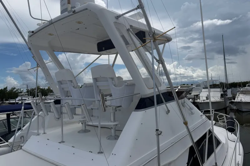 Slide: The Image of 1999 Phoenix 38 SFX Convertible yacht with flybridge, docked under cloudy skies. - 8