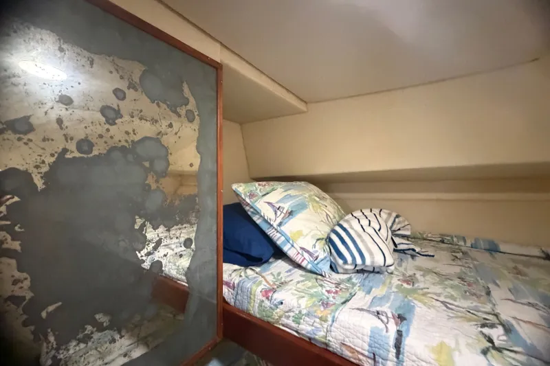 Slide: The Image of Cozy cabin interior of 1999 Phoenix 38 SFX Convertible with nautical-themed bedding. - 49
