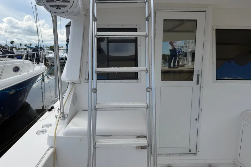 Slide: The Image of 1999 Phoenix 38 SFX Convertible yacht with ladder and cabin door at marina. - 22