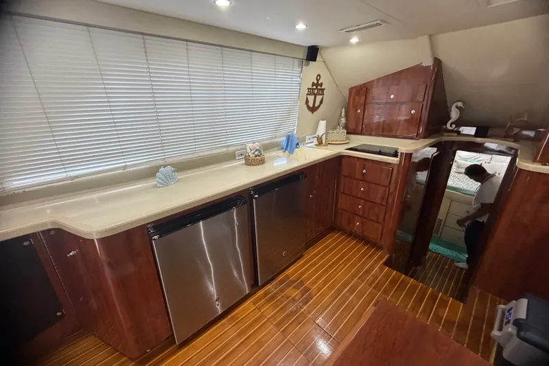 Slide: The Image of Luxurious kitchen interior of 1999 Phoenix 38 SFX Convertible yacht with wooden cabinetry. - 29