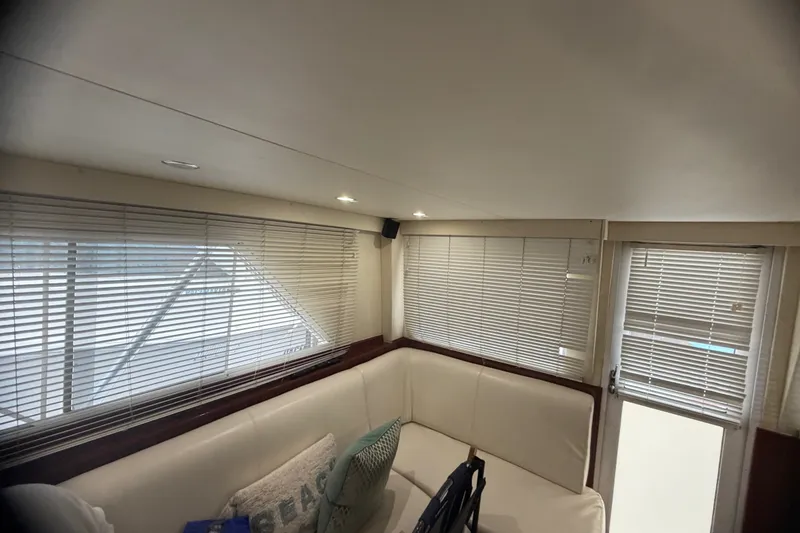 Slide: The Image of Interior of 1999 Phoenix 38 SFX Convertible yacht with white seating and blinds. - 34