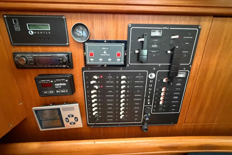 Slide: The Image of Control panel of a 2002 Hunter 356 yacht with various switches and gauges. - 26