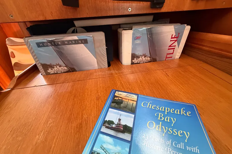 Slide: The Image of Books and brochures on a wooden table inside a 2002 Hunter 356 sailboat. - 25