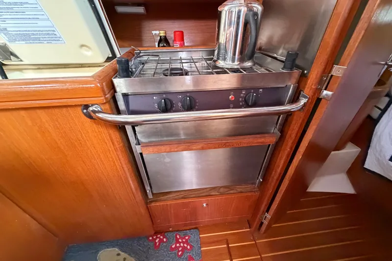 Slide: The Image of Compact kitchen area in a 2002 Hunter 356 yacht with stove and kettle. - 19