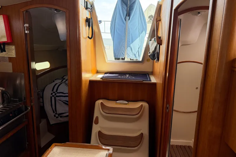 Slide: The Image of Interior of a 2002 Hunter 356 sailboat, featuring wooden cabinetry and cozy sleeping quarters. - 20