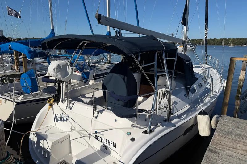Slide: The Image of Sailboat docked at marina, 2002 Hunter 356 model, with blue canopy and visible rigging. - 5