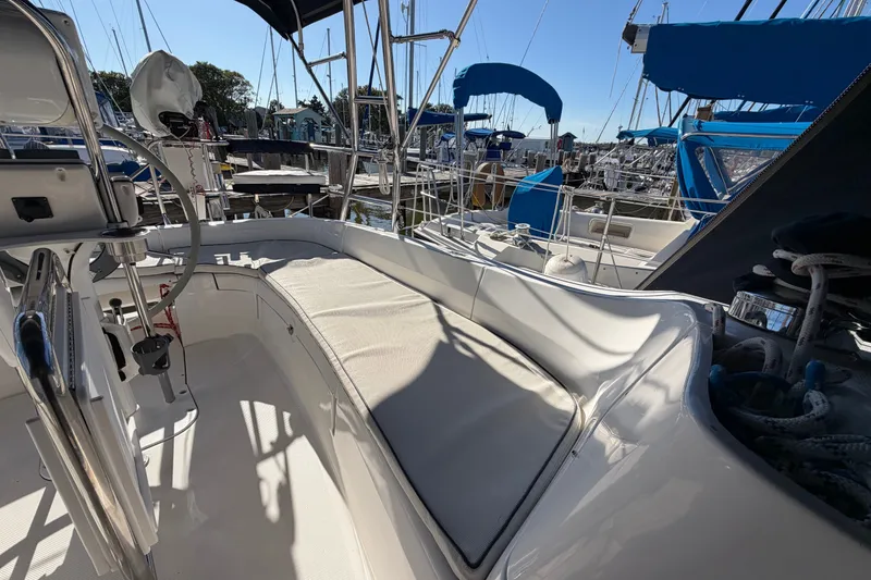 Slide: The Image of 2002 Hunter 356 sailboat cockpit with seating, docked at marina under clear blue sky. - 18