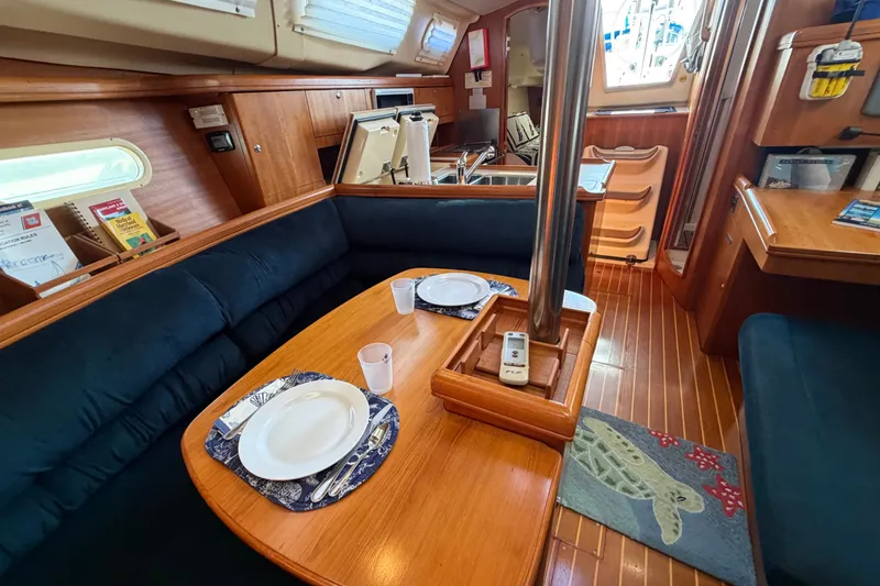 Slide: The Image of Interior of a 2002 Hunter 356 sailboat with dining area and wooden furnishings. - 31