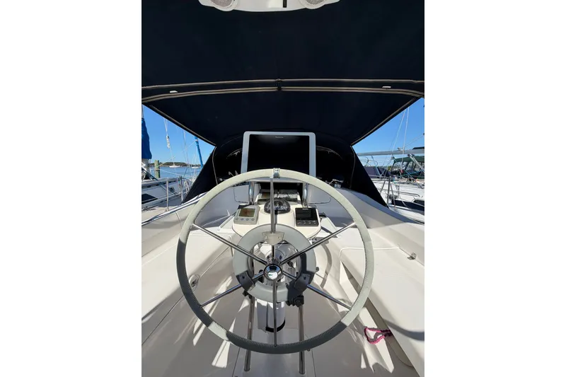 Slide: The Image of Steering wheel of a 2002 Hunter 356 sailboat under a canopy at a marina. - 15