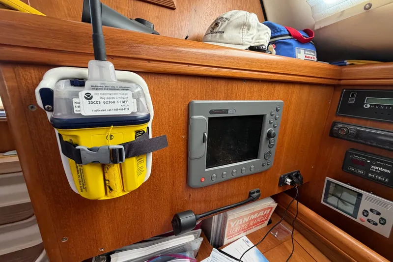 Slide: The Image of Control panel of a 2002 Hunter 356 sailboat with navigation equipment and emergency beacon. - 14