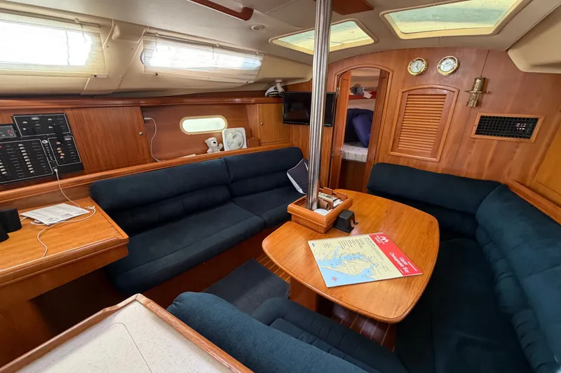 Slide: The Image of Interior of 2002 Hunter 356 sailboat with wooden furnishings and navy seating. - 15