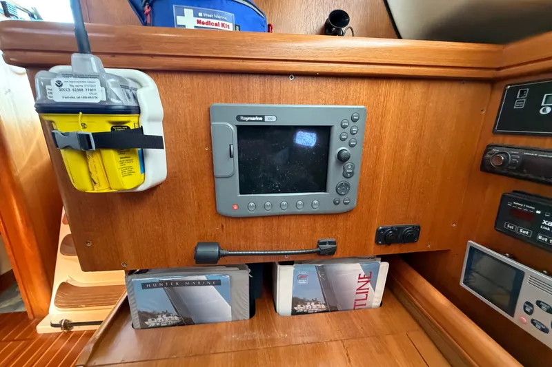 Slide: The Image of 2002 Hunter 356 yacht navigation panel with Raymarine display and safety equipment. - 24